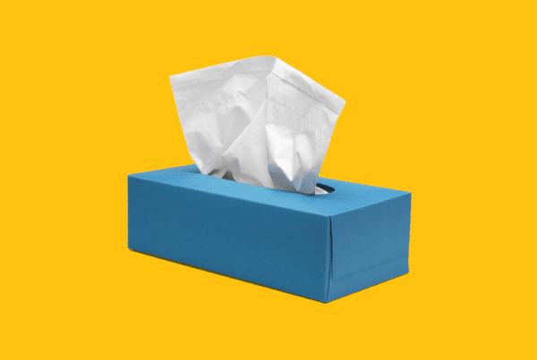 A blue tissue box with one tissue poking out, on top of a yellow background