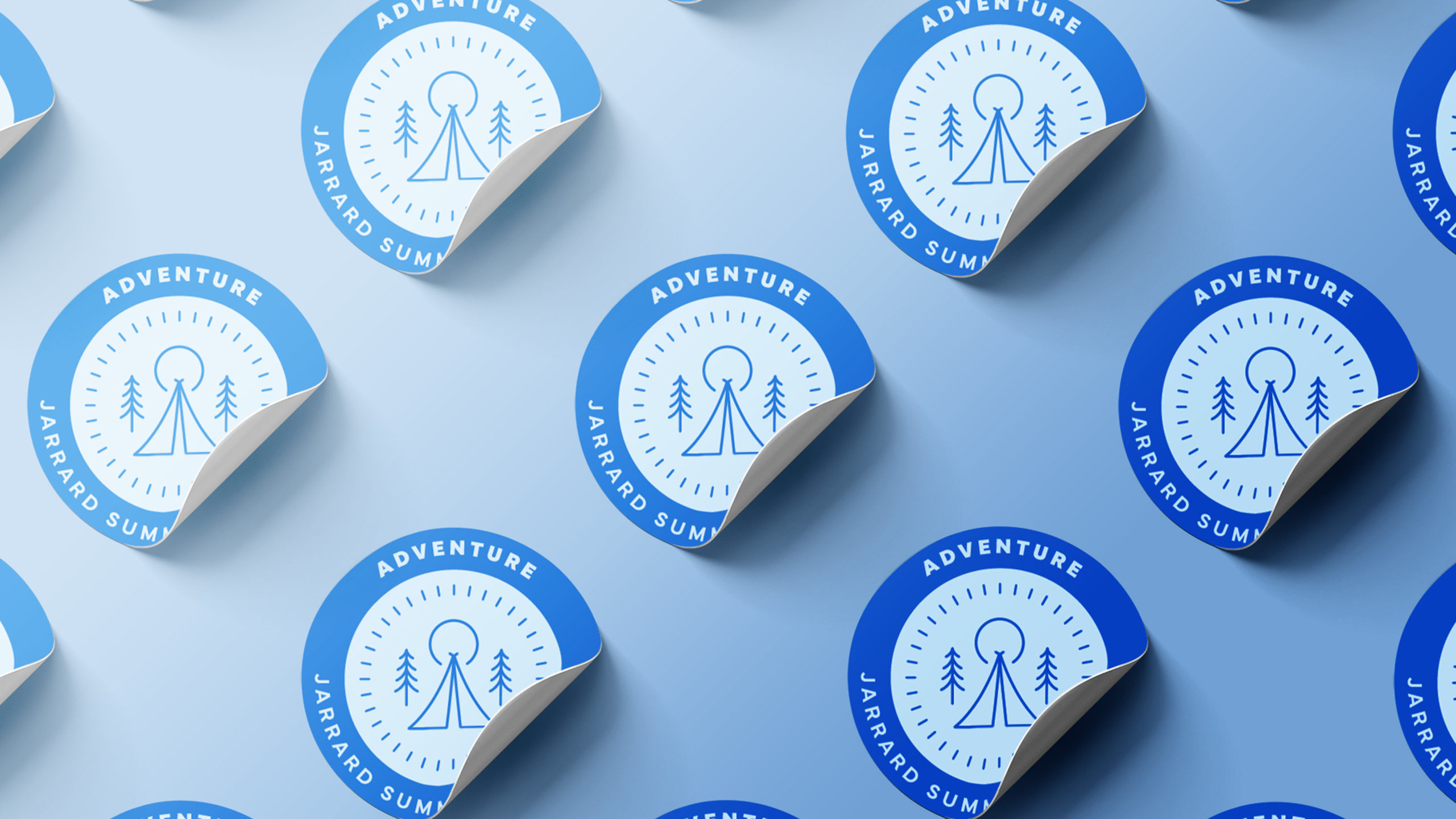Adventure-Sticker-multiple-scaled An assortment of blue stickers with camping icons laid out on a blue background